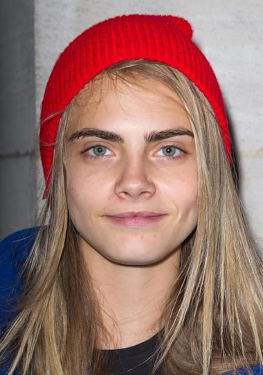 Cara Delevingne wearing a red beanie without makeup on