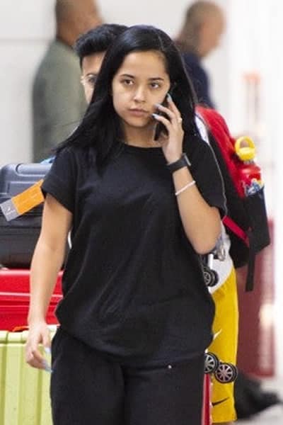 Becky G talking on the phone through the airport