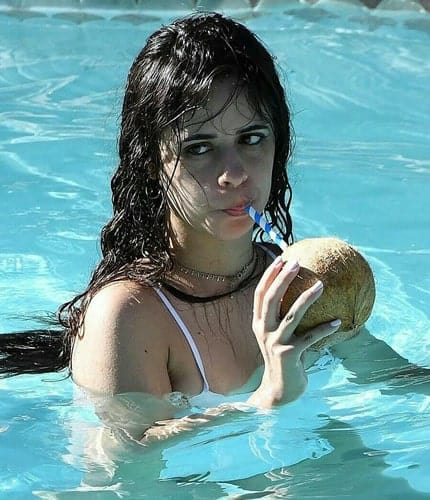 Camila Cabello drinking coconut by the pool