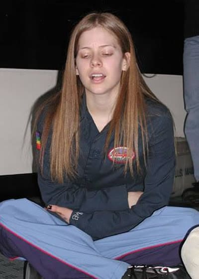 Avril Lavigne sitting down without eyeliner